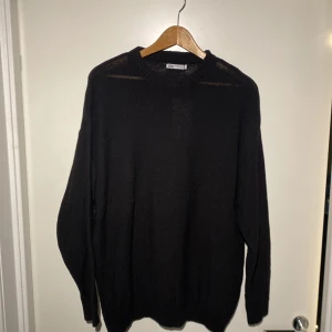 Svart tröja från Zara - Säljer en stilren svart tröja från Zara. Tröjan har en klassisk design med långa ärmar och rund hals. Perfekt för en minimalistisk look. Passar bra till både jeans och chinos. Helt ny och aldrig använt.