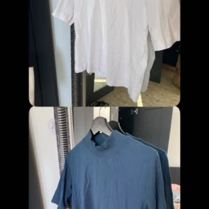 Vit och blå t-shirt med hög krage - Två stilrena t-shirts i vitt och blått med hög krage. Perfekta för en avslappnad look. Kortärmade och tillverkade i ett mjukt material för extra komfort. Ena tröjan är i storlek L och den andra i storlek M:)