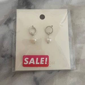 Örhängen med pärlor från Lily and Rose - ⚠️Aldrig andvända⚠️!!⚠️pris går och diskuteras⚠️Örhängen från Lily and Rose med en stilren design. De har en rund silverfärgad ring och en hängande vit pärla.💗