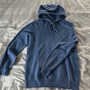 Blå kashmir hoodie - Säljer en snygg blå kashmir hoodie med långa ärmar och dragsko i huvan. 