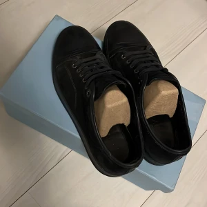 Marin blåa sneakers från Lanvin - Snygga svarta sneakers från Lanvin med klassisk design. Skorna har snörning och en stilren look, perfekt för en modern stil. De kommer med originalförpackning och dustbags. Man får med extra snören i boxen. Dom har inga större skador 