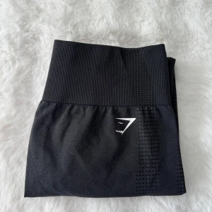 Svarta träningstights från Gymshark - Snygga svarta leggings från Gymshark med hög midja och diskret logga i midjan💕Perfekta för träning med sin stretchiga och bekväma passform. Materialet är syntetiskt och andas bra💕 storlek xl💕