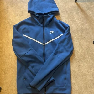 Nike tech fleece - Säljer en blå Nike tech fleece i vuxen storlek XS. Skick 10/10 eftersom den endast är testad och inte används. Perfekt för en sportig look. Priset kan sänkas vid snabb affär.