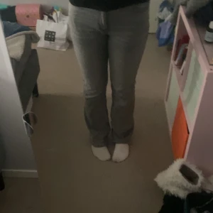 Grå jeansbyxor midwaist  - Snygga grå jeansbyxor med en klassisk design. De har en rak passform och är perfekta för en avslappnad stil. Byxorna har fickor fram och bak samt en dragkedja och knapp framtill. 