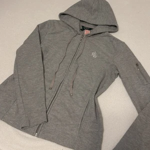 Grå Zip hoodie S - Super snygg sitter bra på kroppen, vid armen finns en ficka så nån liten grej får plats som hörlurar.