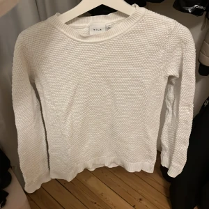 Vit stickad tröja från Vila - Säljer en stilren vit stickad tröja från Vila. 🥰Tröjan har en texturerad yta och är mjuk och bekväm med ribbade kanter vid ärmslut och nederkant. Något liten i storleken skulle säga att den passar XS/S bättre än M☺️Använd men fortfarande mycket bra skick!💕