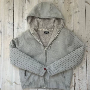Fodrad cardigan - En riktigt snygg cardigan/hoodie som passar perfekt nu till vintern. Den är riktigt fet och har inte några större defekter. På andra bilden kan man dock se ett litet hål i ena ärmen. Men detta är inget som man lägger märke till. 