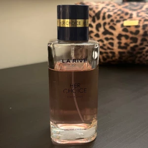 La Rive Her Choice Eau de Parfum - Elegant parfymflaska från La Rive med doften 'Her Choice'. Perfekt för den som söker en sofistikerad och feminin doft. Ca 80 ml kvar