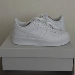 Vita Nike Air Force sneakers - Säljer ett par klassiska vita Nike Air Force sneakers. Storlek 38 helt nya oanvända perfekt till                vår/sommaren! Pris kan diskuteras