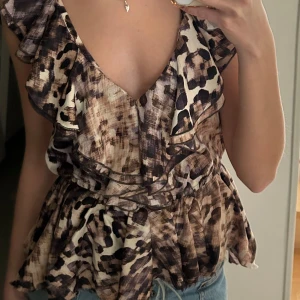 Blus - Blus med djurmönster o volang längst ner