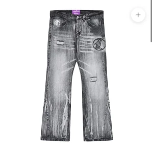 Grå jeans med slitningar och tryck - Snygga Flared grå jeans med coola slitningar och ett unikt tryck på benet. 