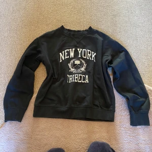 Svart sweatshirt - Säljer en svart sweatshirt med tryck 'New York Tribeca' i vitt. Tröjan har långa ärmar och en klassisk rund halsringning. Perfekt för en avslappnad stil.❤️Så mysig att ha på sig, passar till allt😻