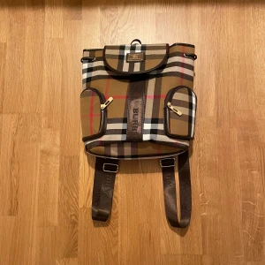 Burberry ryggsäck - Burberry ryggsäck i det ikoniska Burberry mönstret. Ryggsäcken är använd, defekter förekommer på sista bilden, hör av vid minsta fundering!