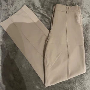 Beigea kostymbyxor från Madlady - Snygga beige kostymbyxor från Madlady i storlek M. Byxorna har en stilren design med medelhög midja och raka ben. Som nya och använda väldigt få gånger☺️