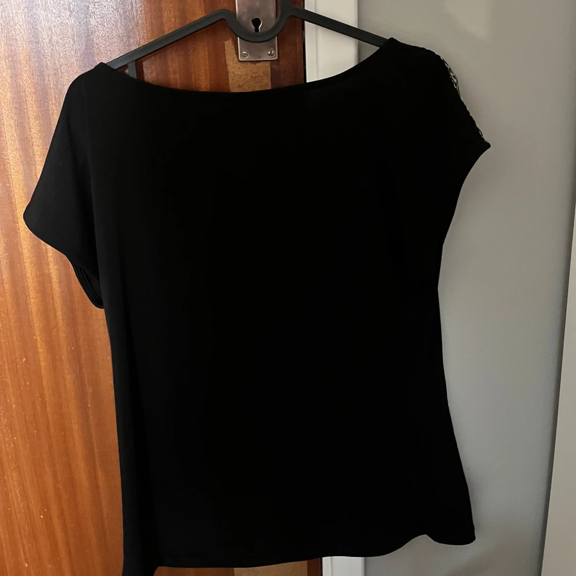 Svart t shirt som har en liten rand leopardmönster på axeln på varsin sida! - 92