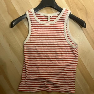 Randig ribbad linnetopp från H&M - Säljer en superfin randig linnetopp från H&M i storlek M men passar precis lika bra som S. ☺️Den är vit med röda ränder och har en ribbad struktur. Perfekt för sommardagar eller som ett lager under en kofta. Toppen är i mycket bra skick och redo för nya äventyr!💗