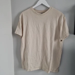 Beige t-shirt från Urban Classics - Säljer en stilren beige t-shirt från Urban Classics i storlek S. Den är i bra skick och perfekt för skate stil då där en loose fit och tjockare tyg. T-shirten är kortärmad och gjord av mjuk bomull, vilket gör den bekväm att bära hela dagen. 