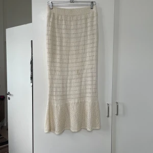 Beige stickad kjol från Bohemian - Superfin beige stickad kjol från OXXO i storlek M(fläcken är borta vid det här laget). Kjolen är lång och har en volangdetalj längst ner som ger en romantisk touch. Perfekt för höst och vår, och kan stylas både upp och ner beroende på tillfälle. Den är i mycket bra skick och redo för nya äventyr!