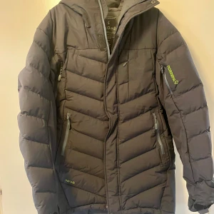 Svart dunjacka från Norrøna - Säljer en svart dunjacka från Norrøna, . Jackan har huva. Den är i mycket bra skick - PrimaLoft-foder. Passar både till vardags och utomhusaktiviteter. Snarare Medium än small.