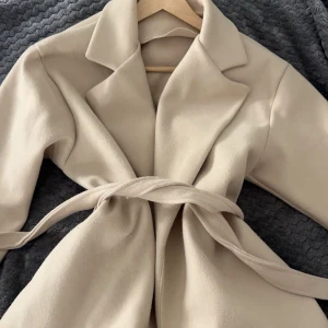 Beige kappa med bälte - Säljer en superfin beige kappa i mycket bra skick ifrån missäy. Jättebra skick❤️ köpt för 500✨