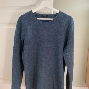 Blå stickad tröja från Selected Homme - Säljer en snygg blå stickad tröja från Selected Homme i storlek M. Tröjan är gjord av en mjuk blandning av bomull och akryl, perfekt för kyliga dagar. Den har en klassisk rund hals och långa ärmar. Perfekt för både vardag och lite finare tillfällen. 🧶💙