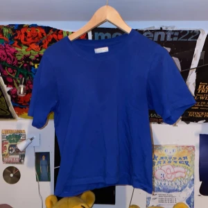 Blå t-shirt från Lindex - Säljer en snygg blå t-shirt från Lindex i storlek S. Den är i bra skick och perfekt för vardagsbruk. Gjord av mjukt bomullsmaterial. Passar perfekt till både jeans och shorts!