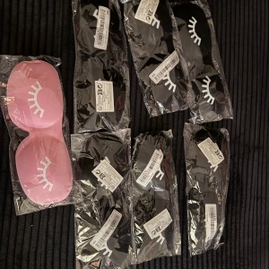 Sovmasker med ögonfransmotiv - Säljer flera sovmasker i svart och rosa med ett sött ögonfransmotiv. Perfekt för en god natts sömn eller en avkopplande tupplur. Maskerna är nya och kommer i förpackning. De är mjuka och bekväma att bära.