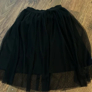 Svart tyllkjol - Säljer en superfin svart tyllkjol i kort modell. Kjolen har ett lager av prickigt tyll som ger en snygg och trendig look. Perfekt för fest eller en utekväll! Den är i bra skick och passar till många olika outfits. 🖤