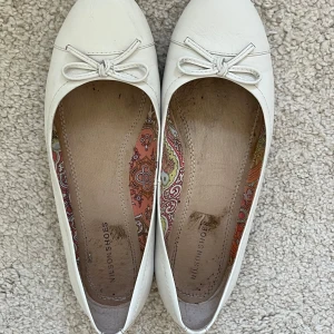 Vita ballerinaskor med rosett - Säljer ett par jättesöta vita ballerinaskor från Nilson Shoes då de är för stora för mig. De har en fin rosett på ovansidan. Perfekta för vår och sommar! De är i bra skick. 🐇