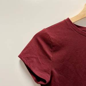 En burgundy otroligt mjuk t-shirt med korta ärmar från Hollister (påminner om träningsmaterial). T-shirten är i en mjuk och bekväm kvalitet. Den är i storlek S, men upplever den lite mindre i storleken så passar också en XS enligt mig. Endast testad.