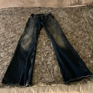 Coola fleared/ bootcut jeans med blekning som börjar vid knäna ish. Ca 70cm hela vägen runt i midjan men har lite stretch så de kan bli 75cm ungefär. 108cm långa nedför benet. Mid rise. Säljer pga att det är försmå. Hela och i bra skick! ✌️❤️