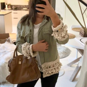 Grön jacka med virkade detaljer - Säljer en superfin grön jacka med unika virkade detaljer vid ärmslut. Den är perfekt för vår och höst🧡🍂🍁