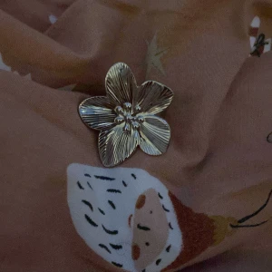 Blomformad ring i silver - Snygg ring i form av en blomma med detaljerade kronblad och små pärlor i mitten. Perfekt för att ge en elegant touch till din outfit. Ringen har en justerbar storlek för att passa de flesta fingrar. Rostfritt stål!💕