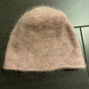 Ljusrosa mössa från FWSS - Mysig ljusrosa mössa från FWSS, tillverkad i en blandning av angora och nylon. Perfekt för kyliga dagar med sin mjuka och fluffiga textur❣️❣️