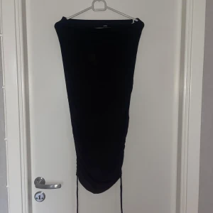 Svart kjol från Shein - Snygg svart kjol från Shein i en tight passform. Kjolen har en stilren design med snörning i nederkant för justerbar längd. Perfekt för en kväll ute eller en speciell tillställning.