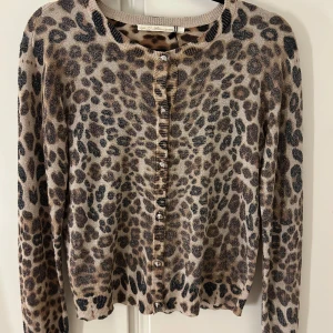 Leopardmönstrad kofta från Gaudi - Snygg leopardmönstrad kofta från Gaudi i beige och flerfärgad design. Den har långa ärmar och knappar framtill. Perfekt för att ge din outfit en trendig touch. Köpt från Sellpy men jag har aldrig använt den😊