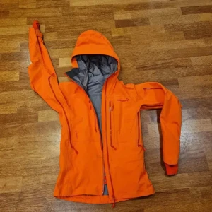 Orange Norrøna Skaljacka - Skaljacka från norrøna för skidåkning, turer eller annat. I fint skick med snölås, liftkort ficka och goretex mm. Jackan är i modell Lofoten. Säljer även matchande byxor i en annan annons. Nypris: 7995kr men årets modell kostar 8999kr. Så här skriven norrøna själva: The original. Den klassiska Lofoten Gore-Tex Pro-jackan är en mycket hållbar och skyddande freeridejacka som ger förstklassig puderfunktionalitet.