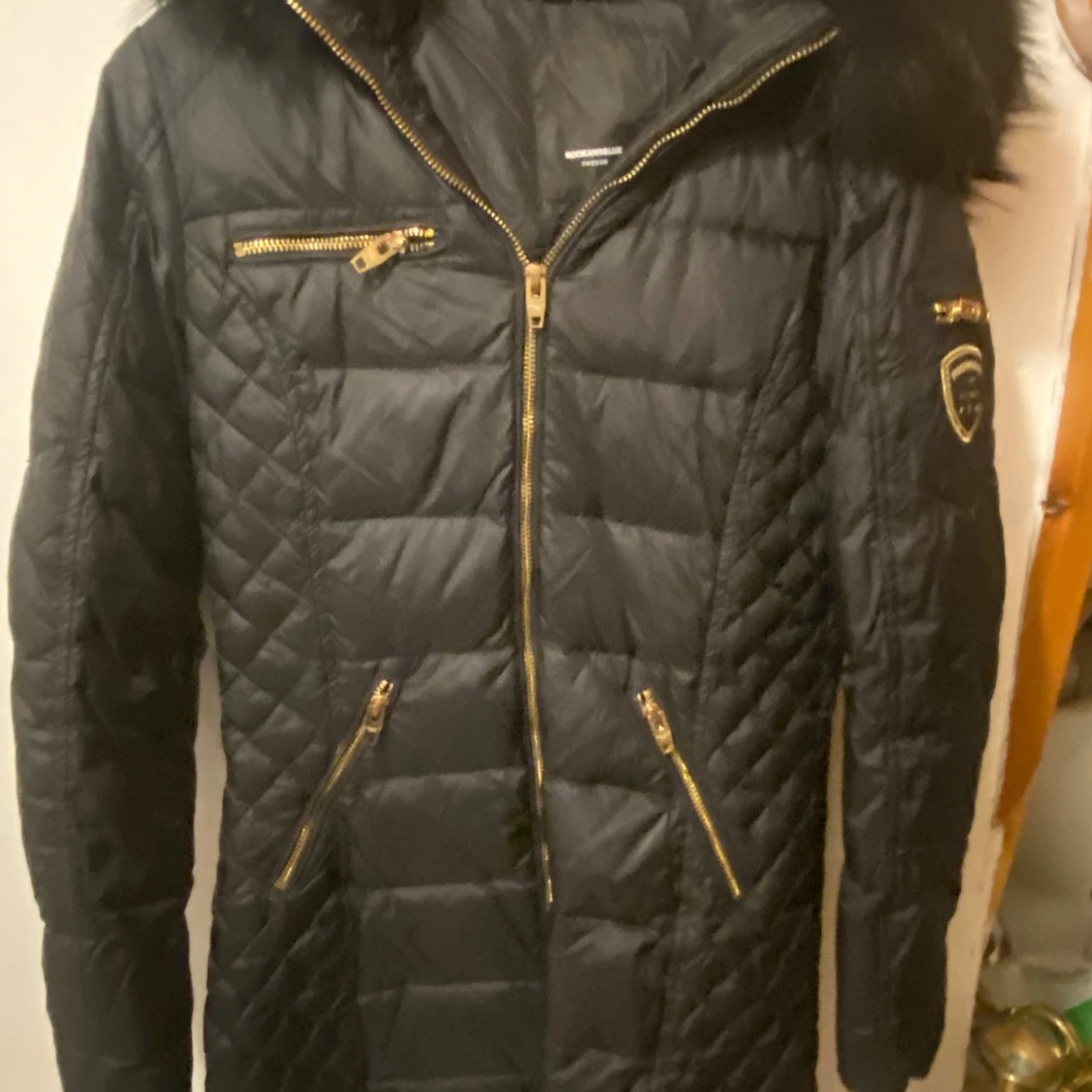 Svart quiltad jacka med pälsdetaljer