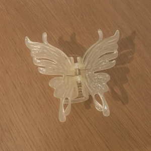 Hårklämma i fjärilsform - Snygg hårklämma i form av en fjäril med en skimrande, pärlemorliknande yta. 