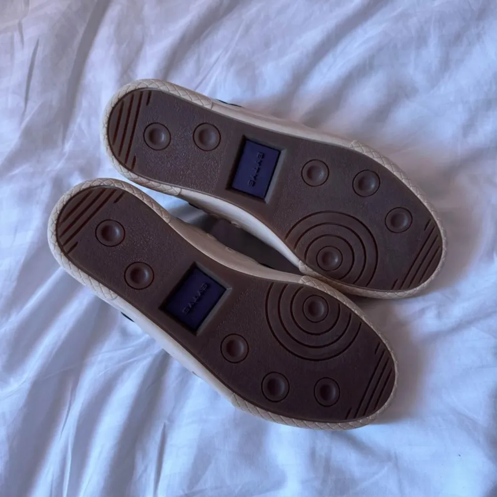 Snygga vita sneakers från Eytys med gröna detaljer och snörning. Skorna har en stilren design med en bekväm sula och är perfekta för en avslappnad stil.. Kengät.