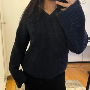 Marinblå ribbad stickad tröja - Mysig marinblå stickad tröja med ribbad struktur och v-ringning. Knappt använd.