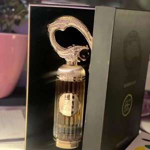 Sehr lattafa - Säljer en lyxig parfym från Lattafa i en elegant guldflaska med en unik design. Flaskan har en dekorativ topp som ser ut som en böjd svans och en mörk sten. Perfekt för den som vill ha något exklusivt på parfymhyllan. Parfymer luktar lyx och skönhet. 99ml kvar! 