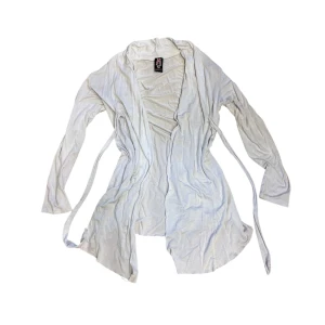 Vit kofta med knytband - Snygg vit kofta med knytband i midjan. Koftan har en avslappnad passform och långa ärmar, perfekt för lager-på-lager-stil. Enkel och stilren design som passar till många olika outfits.