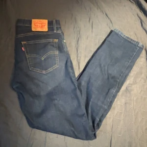 Levis 502 jeans - Snygga Levis 502 jeans i en klassisk blå färg. Dessa jeans har en straight passform och är perfekta för en avslappnad stil. Tillverkade i slitstarkt denim med den ikoniska Levis-loggan på bakfickan. L: 104, B: 46
