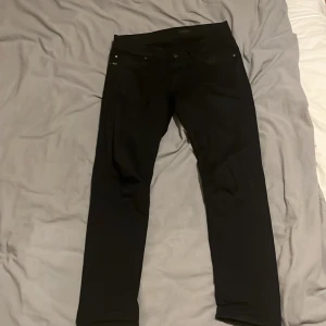 Tiger of sweden jeans  - Snygga svarta byxor med en slim passform. Tillverkade av en bomullsblandning med lite stretch för extra komfort. Perfekta för en stilren look.