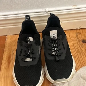 Svarta sneakers från Steve Madden - Snygga svarta sneakers med vit sula och snörning. Skorna har en modern design med en stickad ovandel och detaljer i syntetmaterial. Perfekta för en avslappnad stil. Se sista bilderna för defekterna.