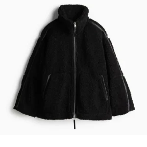 SVART TEDDY/PILE JACKA  - Populär mysig svart teddyjacka med hög krage och dragkedja framtill ifrån hm. Jackan har en oversized passform och stora fickor på sidorna. Perfekt för kyliga dagar. Nyskick och använd fåtal gånger. 