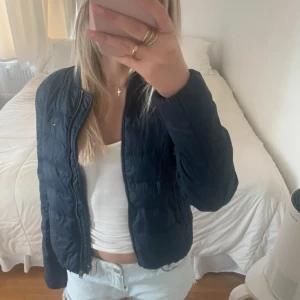 Svart quiltad jacka - Snygg svart quiltad jacka med dragkedja. Perfekt för kyligare dagar och enkel att matcha med olika outfits. Jackan har en normal passform och långa ärmar.