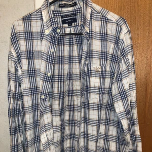 Rutig skjorta från GANT - Rutig skjorta från GANT. Skjortan har långa ärmar och knappar framtill samt en broderad logga på bröstfickan. Perfekt för en stilren look.