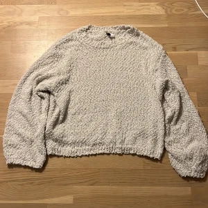 Vit  tröja från H&M Divided - Mysig vit  tröja från H&M Divided med en unik textur. Tröjan har långa ärmar och en avslappnad passform. Den är tillverkad i ett mjukt material som ger en skön känsla mot huden.